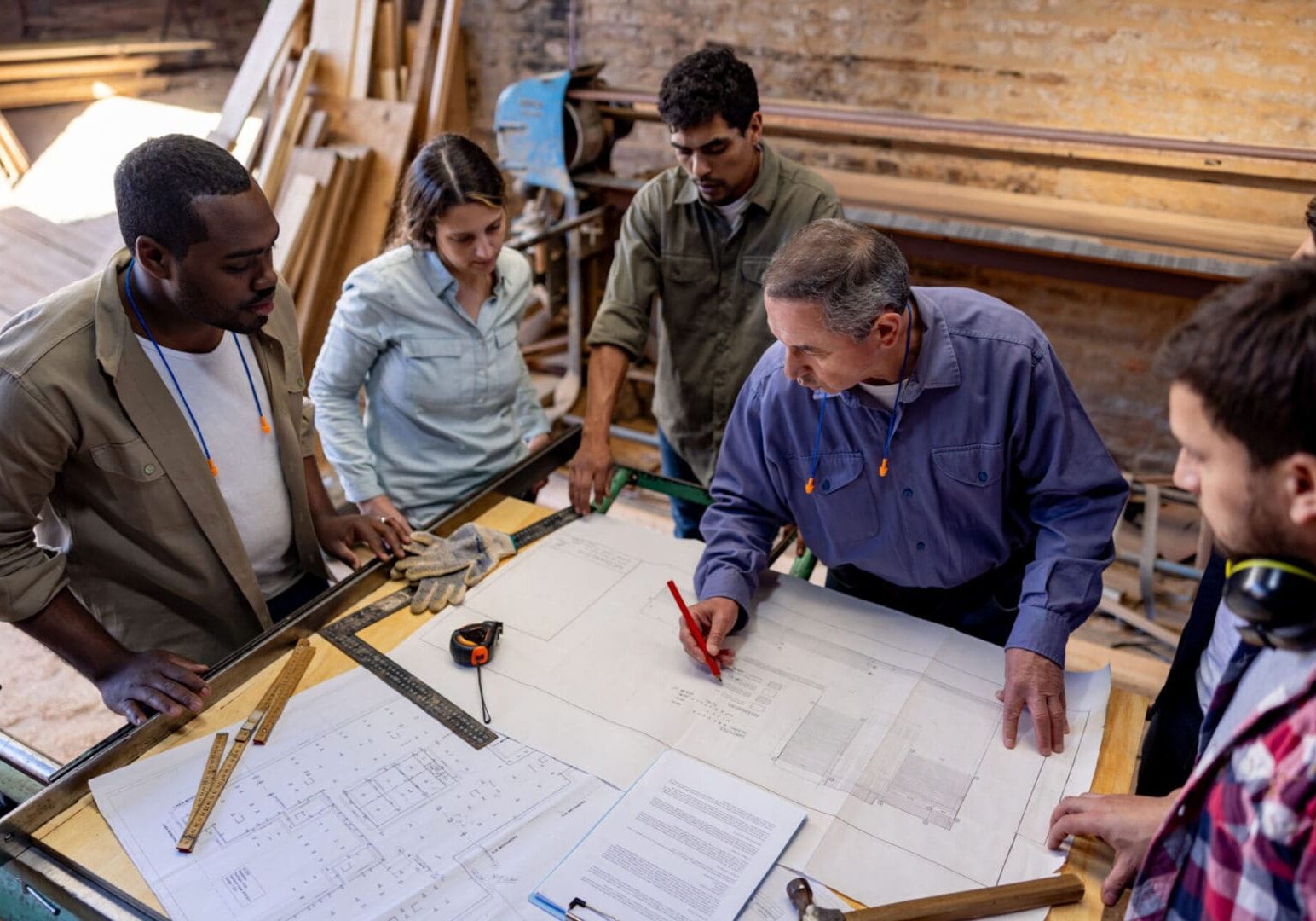Group discussing architectural plans at table.